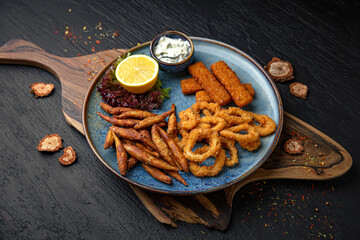 A plate of small deep-fried fish, squid rings and fish sticks.  Menu for a pub on a dark...
