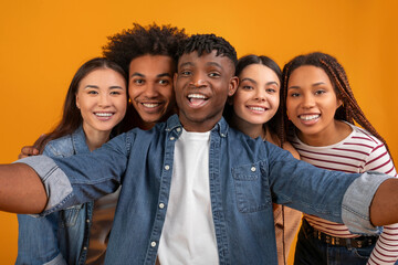 Selfie moment with a multiethnic group on orange background