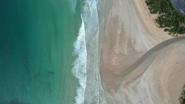 Drone of the beach in Lorne Queenscliff coastal reserve with blue ocean waves and road in the view