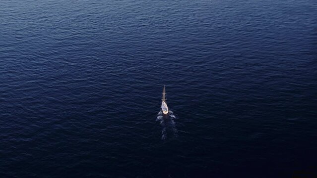 Aerial drone shot of private yacht sailing across open ocean alone. Single boat navigate in open water. Summer gateway. Luxury cruise for tourists destination. Sea adventure. Boats for rent in Europe