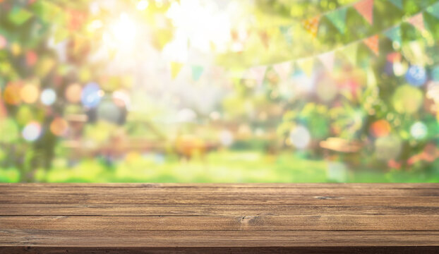 Empty wooden table with party in backyard, blurred  background with festive bunting