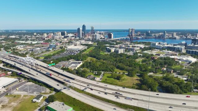 Jacksonville city with high office buildings and American freeway intersection with fast moving cars and trucks. USA transportation infrastructure concept