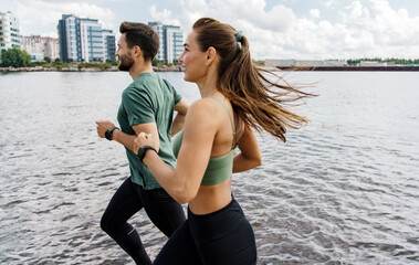 Dynamic duo enjoys a waterfront run, invigorated by the blend of urban views and waterfront serenity.