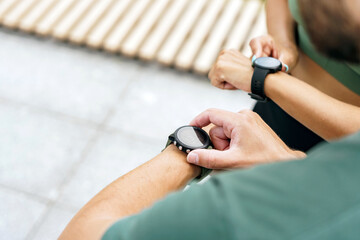 Focused individuals use smartwatches to monitor fitness, highlighting modern health technology.