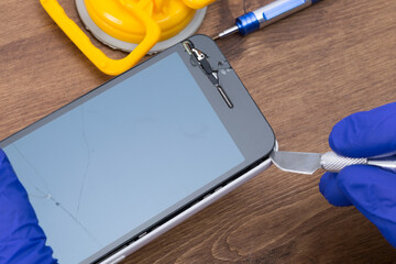 the process of opening a phone with a scalpel, repairing the battery and replacing the glass
