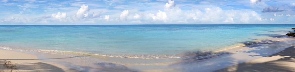 Tropical panorama beach with white clouds and blue caribbean sea.