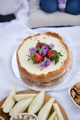 Cake on summer picnic with strawberry and lilac