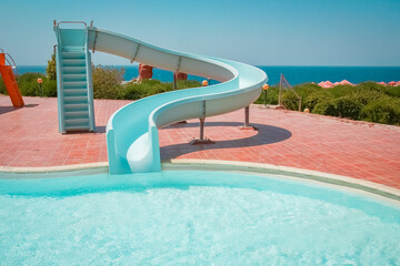 Stylishly interesting water slide in the pool near the sea on nature background