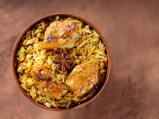 Chicken Biryani with Basmati Rice, Spices and Lemon on Brown Background, Top View, Copy Space