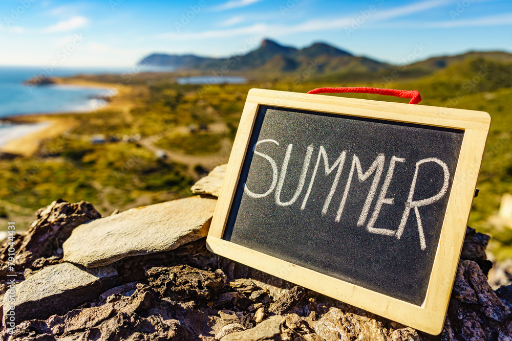 Sticker black board with word summer against sea coast