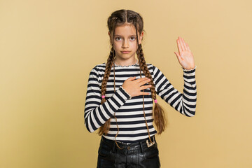 I swear to be honest. Sincere responsible preteen child girl kid raising hand to take oath,...