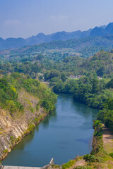 Fototapeta premium An aerial view of the dam-caused canal in Thailand's national park, with a mountain the background. Bird eye view.
