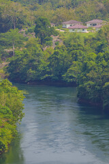 Obraz premium An aerial view of the dam-caused canal in Thailand's national park, with a mountain the background. Bird eye view.