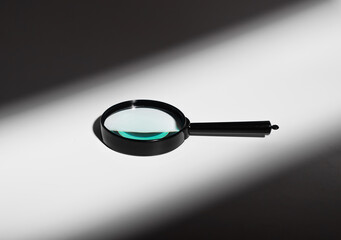 Abstract concept of light and shadow. Glass magnifier lens, transparent handle. Minimal optics