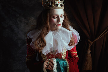 pensive medieval queen in red dress with white collar