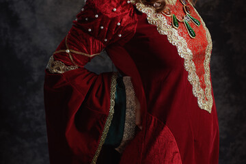 Closeup on medieval queen in red dress having backache