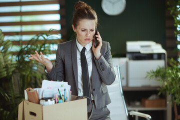 stressed woman worker in green office talking on phone