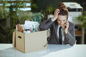 stressed female worker in green office talking on phone