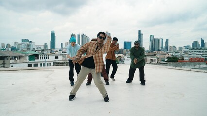 Professional break dance team practice B-boy dance while multicultural friends at rooftop. Young...