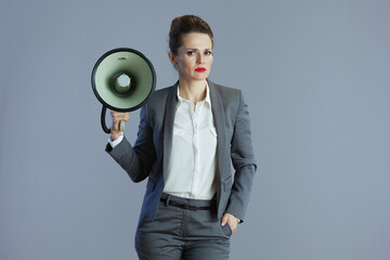 trendy 40 years old business woman against grey background