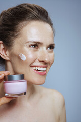 smiling modern woman with cosmetic cream jar