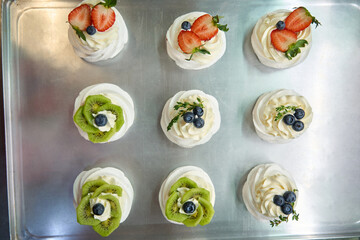 Top-view set of sweet airy meringue nests with swirls of cream