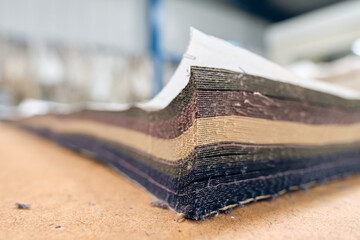 A pile of raw denim sheets fresh off a production line in a denim factory. Industrial fabric and...