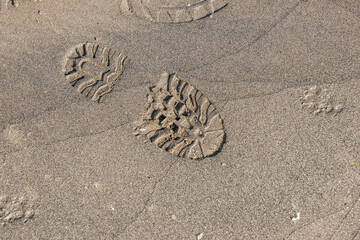 Fussabdruck eines Stiefels mit Profil im Sand