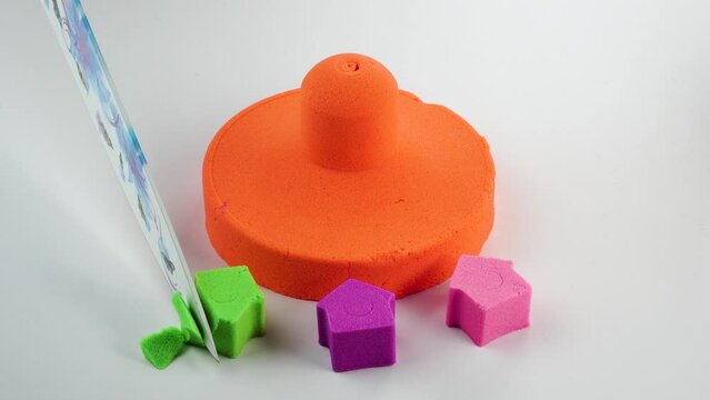 Very Satisfying and Relaxing Kinetic Sand ASMR. Cutting anti stress macro close up colorful Kinetic Sand with a Knife. Kinetic sand cutting with a knife on a black background. ASMR .