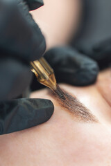 A cosmetologist does permanent tattooing of women's eyebrows