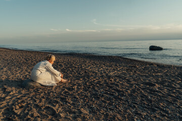 Woman Sitting on Beach by Ocean