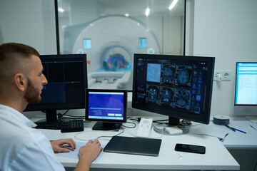Naklejka premium Technologist conducting head MRI on adult person