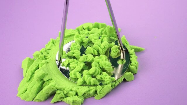 Very Satisfying and Relaxing Kinetic Sand ASMR. Cutting anti stress macro close up colorful Kinetic Sand with a Knife. Kinetic sand cutting with a knife on a black background. ASMR .