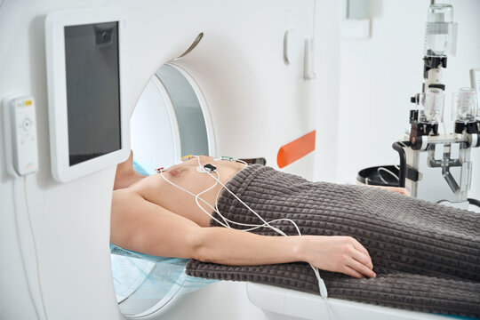 Man undergoing contrast-enhanced ECG-gated coronary CT angiography procedure