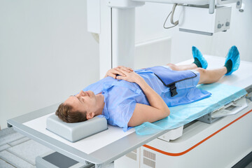 Man getting knee x-ray with digital radiography equipment