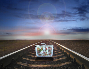old suitcase standing on rails. Farewell to old life. Travel symbol
