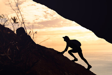 Hiker climbing up mountain cliff, never give up, people perseverance, taking risk 