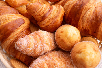 Close-up on sweet bakery products and croissant in the basket captured from above (top view)