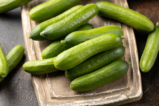 Raw Organic Mini Baby Cucumbers on wooden board. Ready to Eat