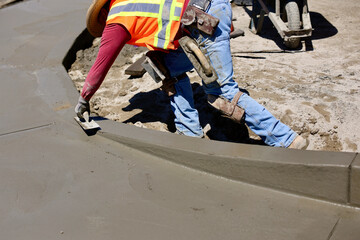 concrete worker puts final touch on wet concrete
