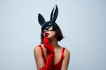 Photo of attractive woman touch sensual face skin rabbit mask red leather clothes isolated on light gray background