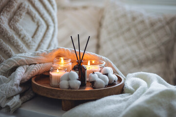 Cozy corner for home meditation, relaxation. Aroma diffuser, burning candles with cotton delicate...