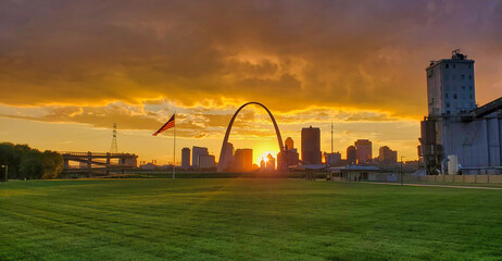 Sun Setting behind the Gateway Arch with a cityscape
