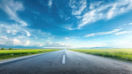 Fototapeta premium Empty road stretching into distance under vibrant blue sky with fluffy clouds