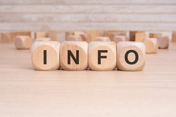 the word INFO is elegantly displayed on a beige hardwood rectangle block