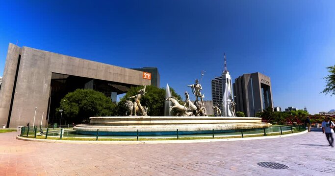 Lockdown Time Lapse Shot Of Famous Fuente De Neptuno At Macroplaza Near Buildings Against Clear Blue Sky - Monterrey, Mexico