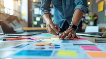 Person planning on colorful sticky notes with charts