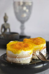 yoghurt dessert with sponge cake, orange and peach. The surface of the cake is filled with jelly with peaches and orange slices. Multilayer dessert - 791132294