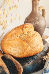 Round white wheat homemade bread. Close-up of white bread with milk and homemade black salt in a...