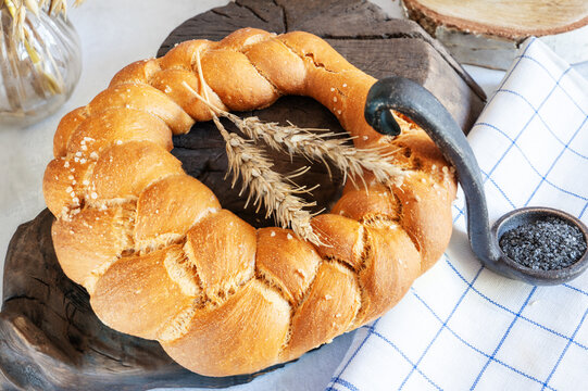 Challah and kalach - round white wheat homemade bread. Close-up of white bread with soy milk and homemade black salt. Close-up